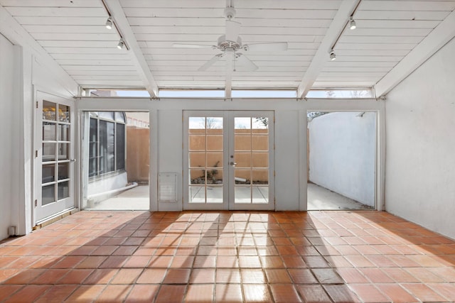 unfurnished sunroom with lofted ceiling with beams, track lighting, ceiling fan, and french doors