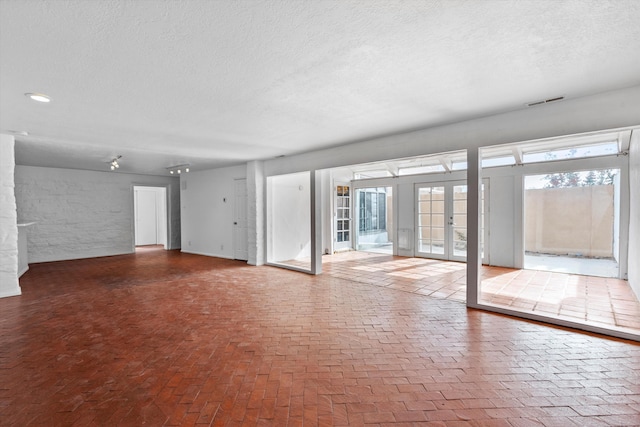 empty room with a textured ceiling and french doors