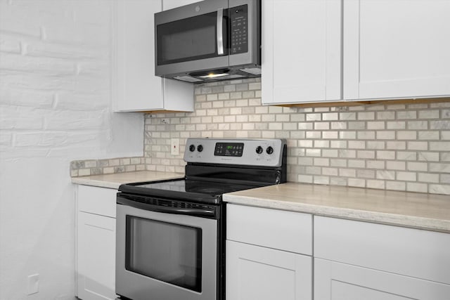 kitchen with tasteful backsplash, stainless steel appliances, and white cabinets