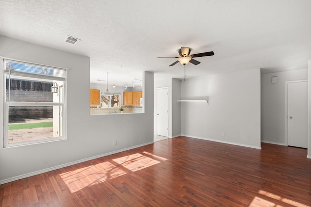 unfurnished living room with hardwood / wood-style flooring, ceiling fan, and a textured ceiling