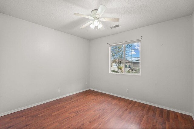 spare room featuring a textured ceiling, ceiling fan, and dark hardwood / wood-style floors