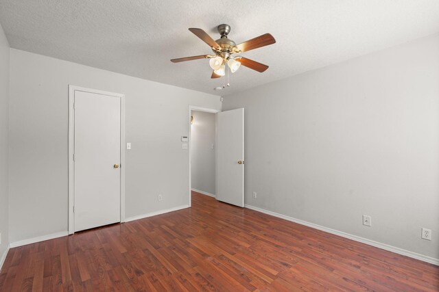 empty room featuring ceiling fan, dark hardwood / wood-style floors, and a textured ceiling