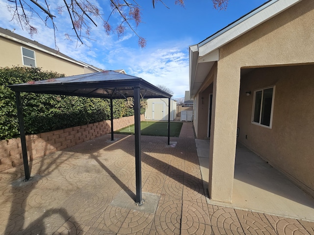 view of patio with a gazebo and a storage unit