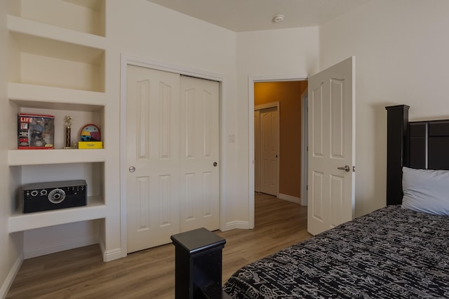 bedroom with light hardwood / wood-style floors and a closet