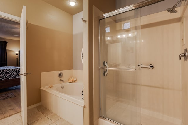 bathroom with separate shower and tub and tile patterned flooring