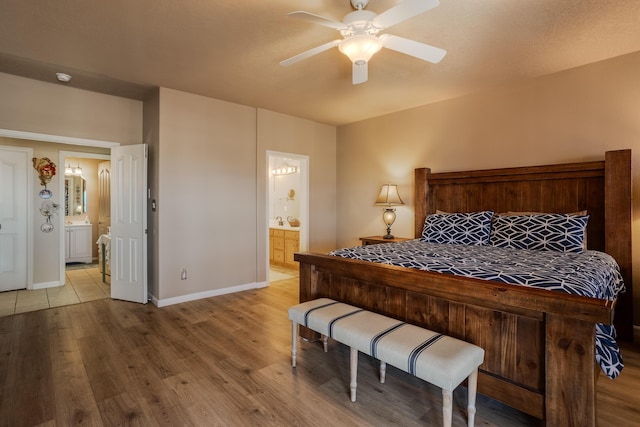 bedroom featuring ceiling fan, ensuite bathroom, and light hardwood / wood-style flooring