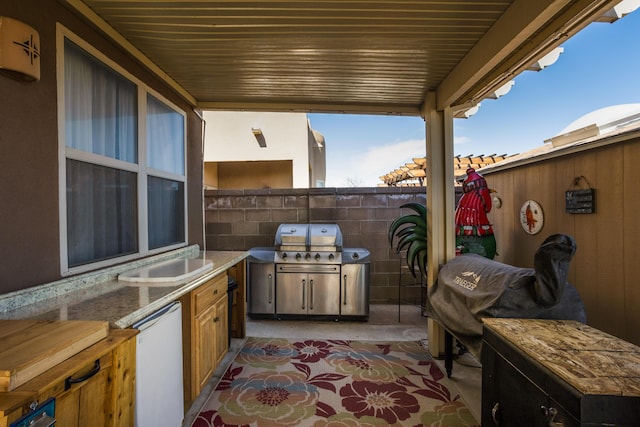 view of patio with an outdoor kitchen, a grill, and sink