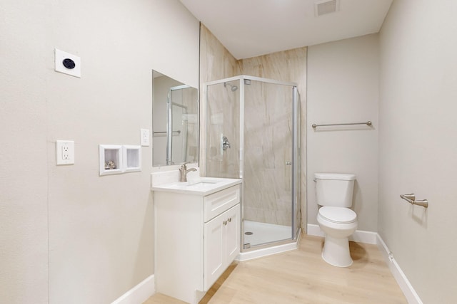 bathroom with toilet, vanity, visible vents, and a shower stall