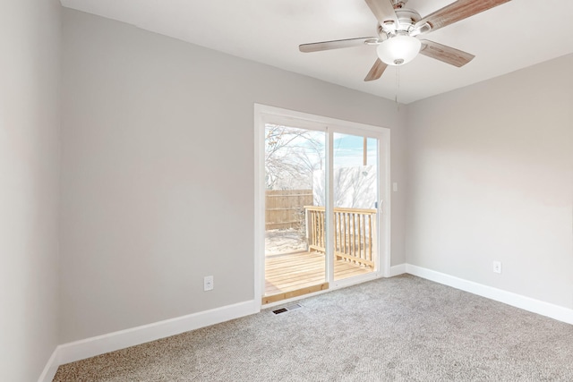 carpeted spare room with ceiling fan, visible vents, and baseboards