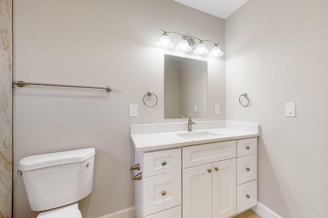 bathroom featuring vanity, toilet, and baseboards