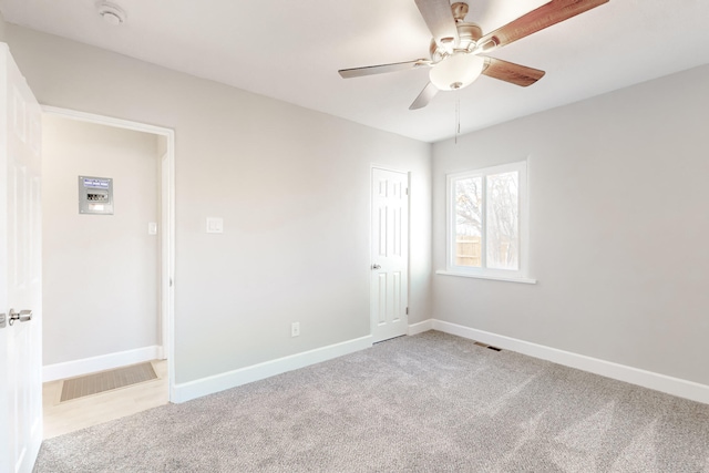 spare room with carpet floors, baseboards, and visible vents