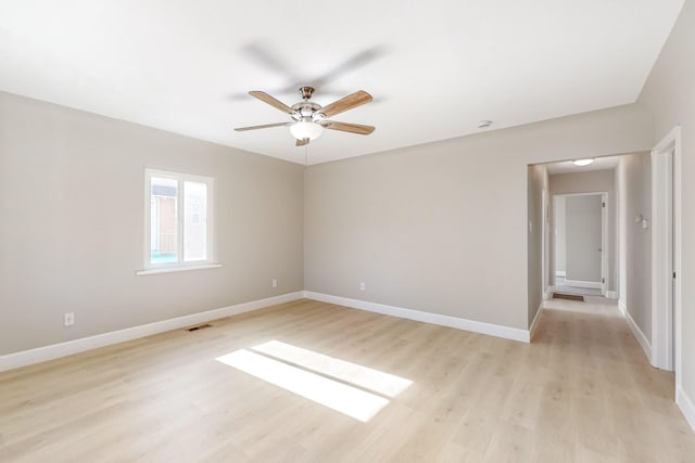 unfurnished room featuring light wood-style floors, visible vents, baseboards, and ceiling fan