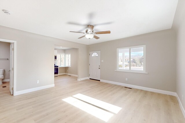 interior space with visible vents, ceiling fan, light wood finished floors, and baseboards