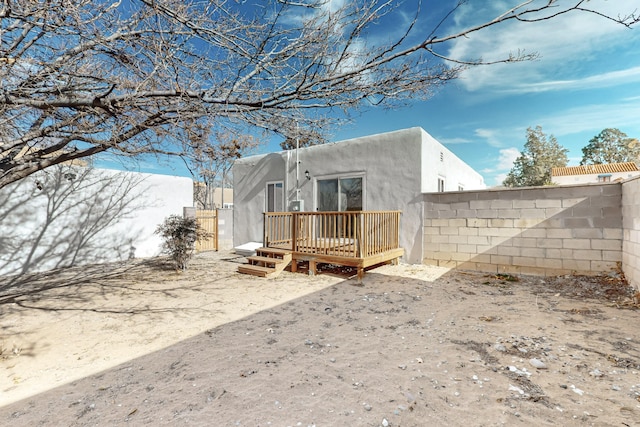 back of property featuring a deck, a fenced backyard, and stucco siding