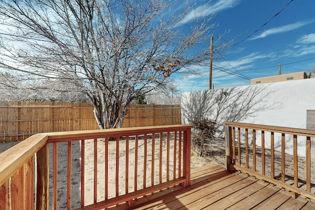 wooden terrace with a fenced backyard