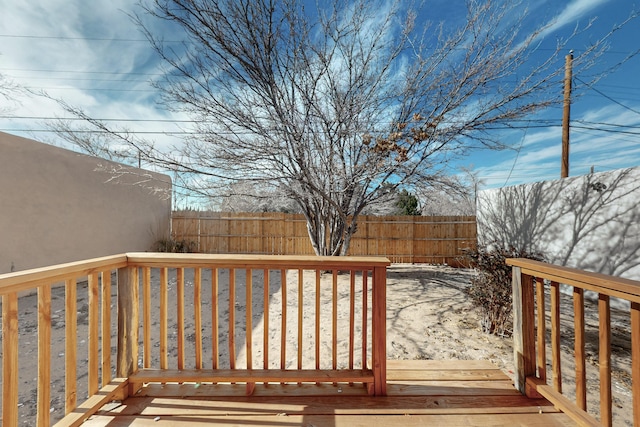 wooden terrace with a fenced backyard