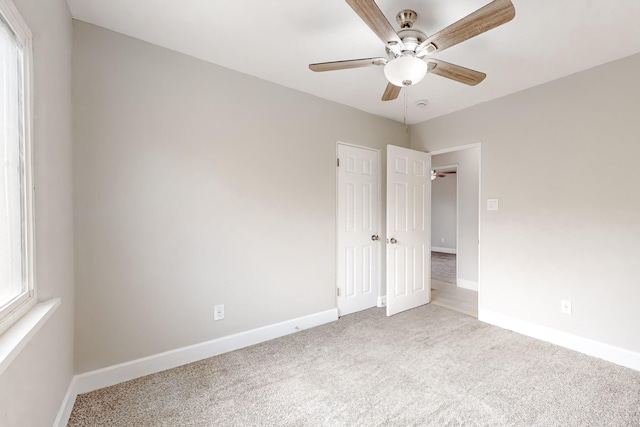 unfurnished bedroom featuring ceiling fan, carpet, and baseboards