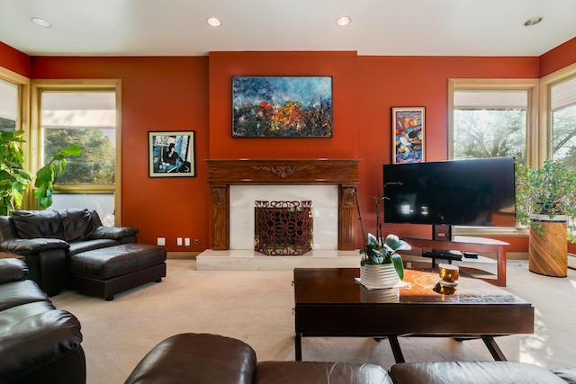 carpeted living room with a high end fireplace and a wealth of natural light