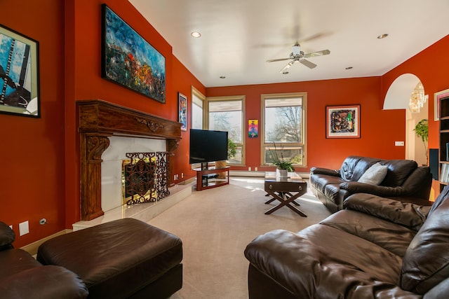 carpeted living room featuring ceiling fan and a premium fireplace