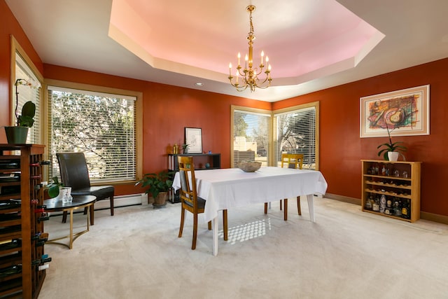 carpeted dining area with an inviting chandelier, baseboard heating, and a tray ceiling