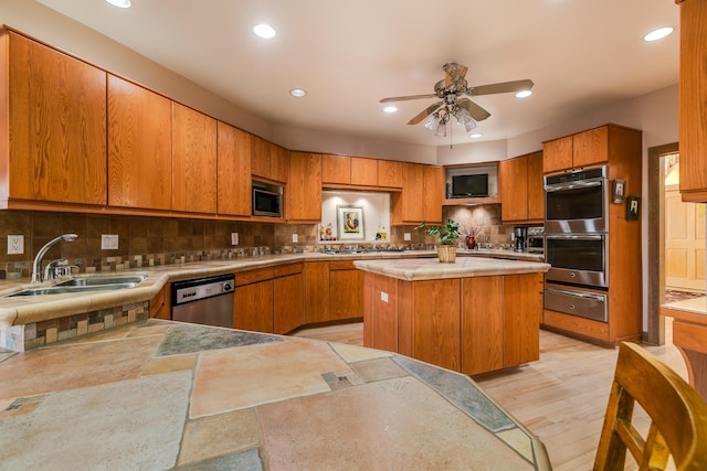 kitchen featuring sink, appliances with stainless steel finishes, kitchen peninsula, a kitchen island, and backsplash