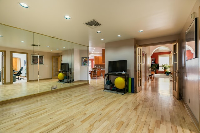 exercise room with light hardwood / wood-style floors