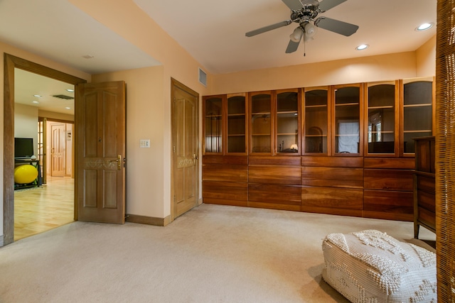 interior space featuring light colored carpet and ceiling fan