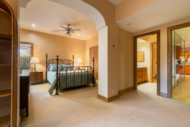 bedroom with light colored carpet and connected bathroom