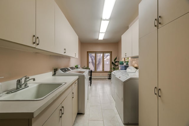 laundry room with cabinets, independent washer and dryer, sink, and light tile patterned floors