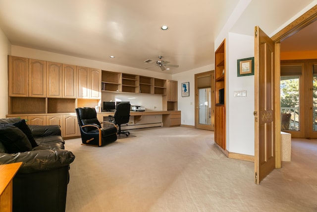 office space with light carpet, built in desk, a baseboard radiator, and ceiling fan