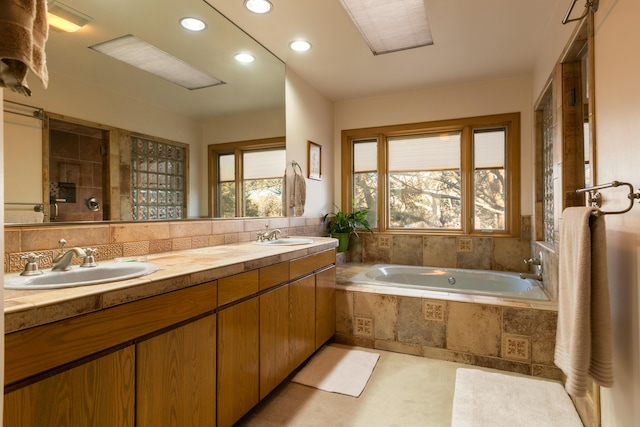 bathroom featuring vanity and tiled tub