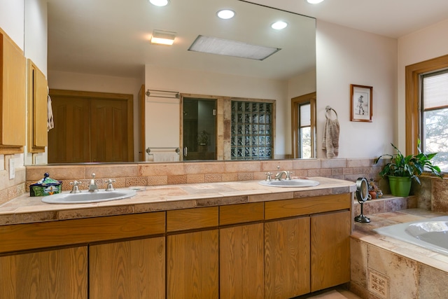 bathroom featuring vanity, decorative backsplash, and a relaxing tiled tub