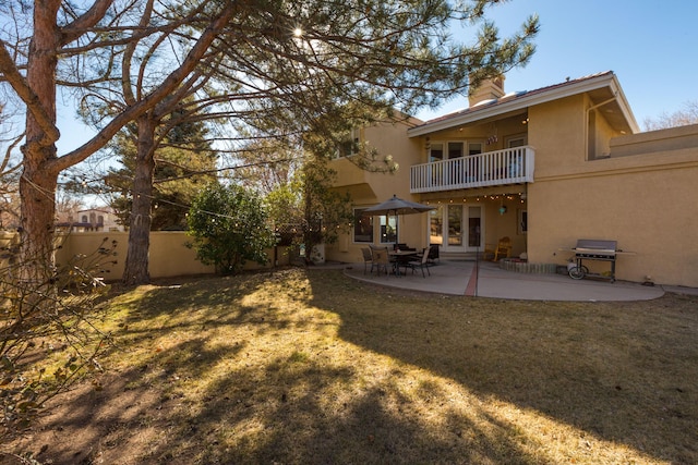 rear view of house with a yard, a patio area, and a balcony