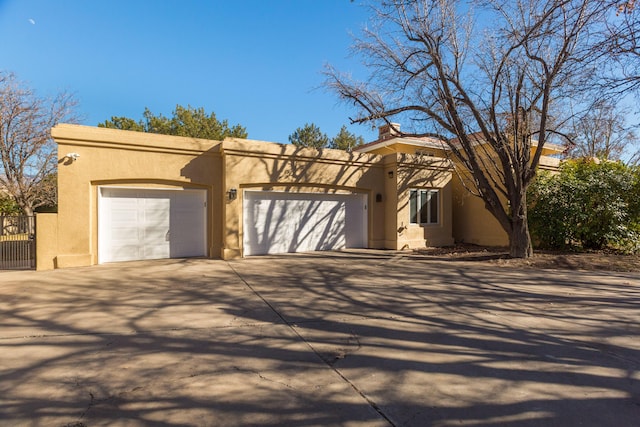 pueblo revival-style home featuring a garage