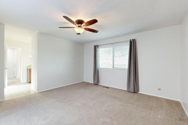 carpeted empty room with ceiling fan and a textured ceiling