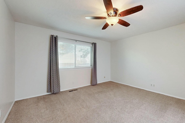 spare room featuring light colored carpet and ceiling fan