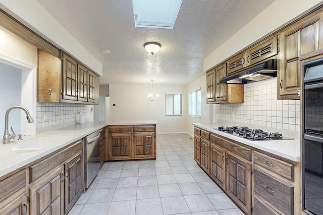 kitchen featuring sink, light tile patterned floors, appliances with stainless steel finishes, kitchen peninsula, and pendant lighting