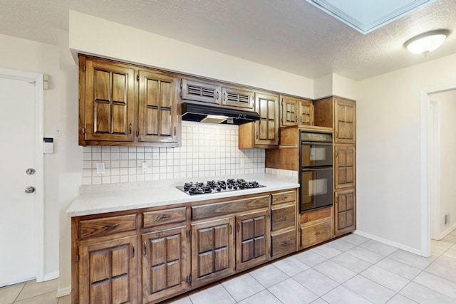 kitchen featuring tasteful backsplash, black double oven, light tile patterned floors, and gas cooktop