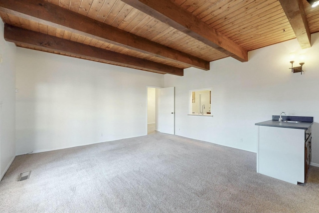 unfurnished living room with carpet flooring, wooden ceiling, and beam ceiling