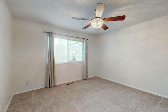 carpeted empty room with ceiling fan and a textured ceiling