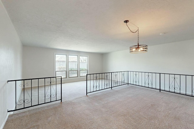 carpeted empty room featuring a textured ceiling