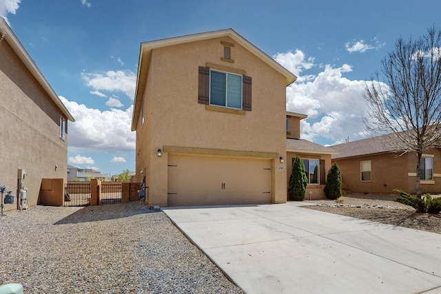 view of front of property with a gate, an attached garage, concrete driveway, and stucco siding