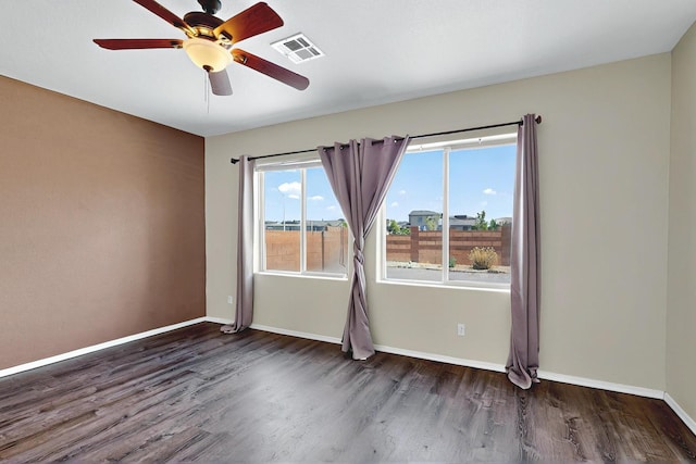 spare room featuring visible vents, baseboards, ceiling fan, and wood finished floors