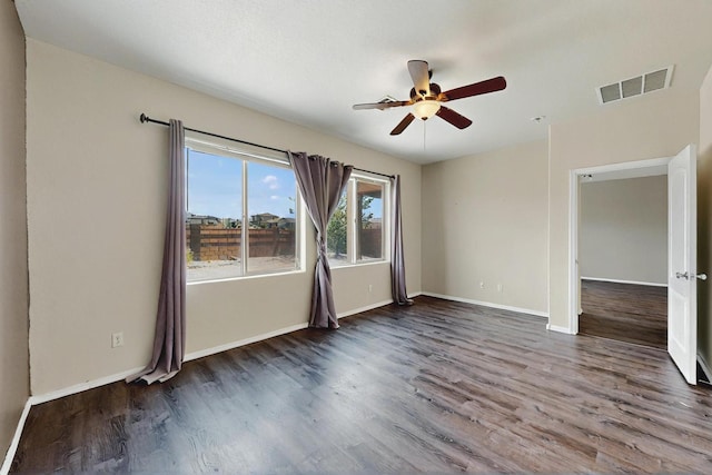 spare room with baseboards, a ceiling fan, wood finished floors, and visible vents