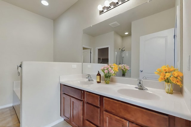 full bath featuring a sink, double vanity, a shower, and visible vents