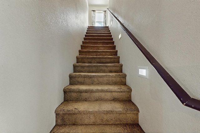 stairs with a textured wall and plenty of natural light