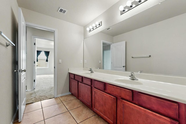 bathroom with double vanity, tile patterned floors, visible vents, and a sink