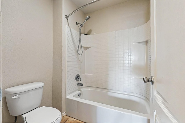 full bath with washtub / shower combination, tile patterned floors, and toilet
