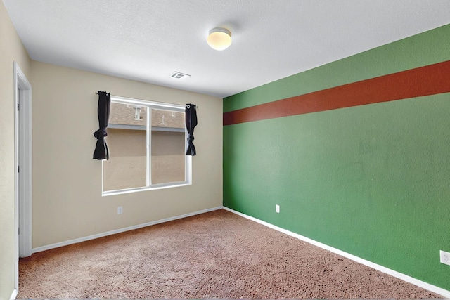 carpeted spare room featuring baseboards and visible vents