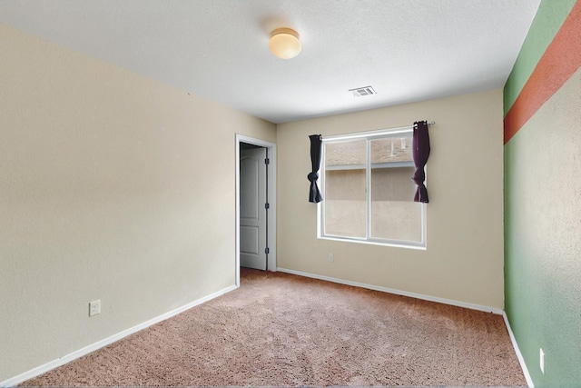 unfurnished room with baseboards, carpet, and visible vents